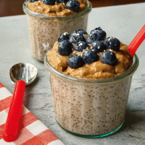 The Ultimate Protein Blueberry Peanut Butter Chia Pudding (Easy & Creamy) 1 creamy protein blueberry peanut butter chia pudding in a jar topped with blueberries and peanut butter