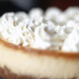 Festive Eggnog Cheesecake Recipe 2 Close-up of a beautifully presented eggnog cheesecake with a golden crust and fluffy whipped cream topping.