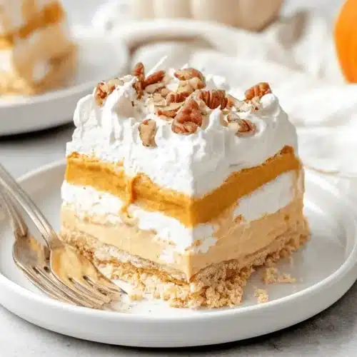 Decadent Pumpkin Lush Recipe: Your Ultimate No-Bake Fall Dessert 3 A beautifully styled slice of multi-layered pumpkin lush dessert, featuring whipped cream and pecan topping, from a delicious pumpkin lush recipe.