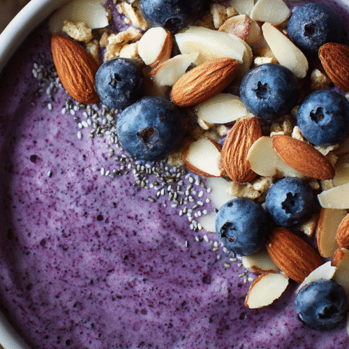 Blueberry Almond Protein Smoothie Bowl Recipe 2 A vibrant blueberry almond protein smoothie bowl topped with fresh blueberries, slivered almonds, and crunchy cereal.